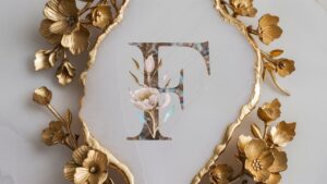 Gold floral accents surround the engraved name "F" for an elegant marble name DP.