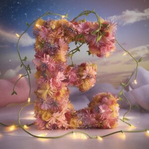 The letter E beautifully crafted from flowers, with soft glowing lights and vines creating a fantasy look."