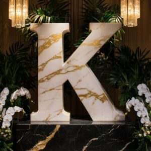 A beautiful letter "K" crafted from rich marble and displayed with greenery, perfect for a name DP with class.